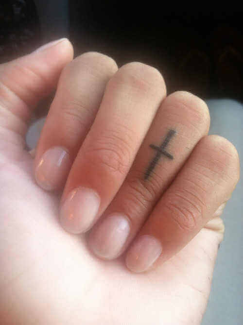 Kreuz-Tattoo auf dem Finger